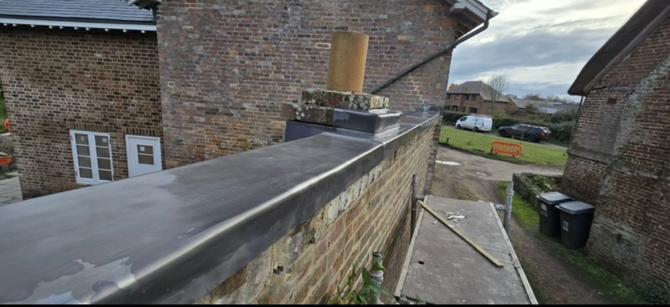 New lead capping along a brick parapet wall